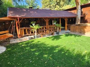 a wooden pavilion with a lawn in front of it at Refugiul Rustic in Arad