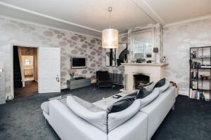 a living room with a white couch and a fireplace at Wisteria House - Sleeps 11 in Buckinghamshire