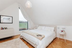 a white bedroom with a bed and a window at Wisteria House - Sleeps 11 in Buckinghamshire