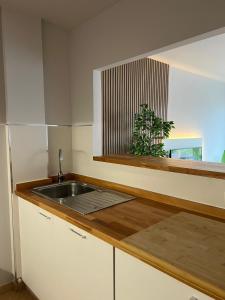 a kitchen with a sink and a window with a plant at Apartamento av.Galicia playa in Finisterre