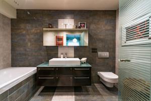 a bathroom with a sink and a tub and a toilet at Capricorn Studio Home in Corfu Town