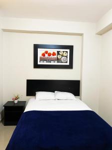 a bedroom with a bed with a blue comforter at Hotel Sengor in Urbanizacion Buenos Aires