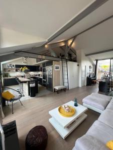 een woonkamer met een bank en een tafel bij Superbe loft climatisé à Suresnes avec terrasse in Suresnes