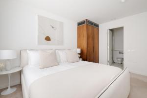 una camera bianca con un letto bianco e un tavolo di Luxury Central Mayfair Townhouse with A/C 3BR 3BA a Londra