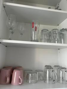 a shelf filled with glasses and other glass items at Mieszkanie w Centrum in Białystok