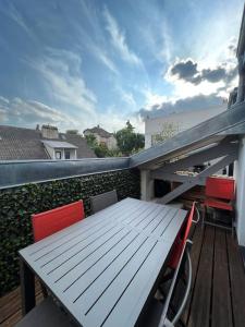 een houten tafel en stoelen op een balkon bij Superbe loft climatisé à Suresnes avec terrasse in Suresnes