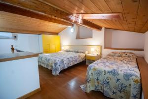 two beds in a room with wooden ceilings at Camping Bungalow Lido in Capoliveri