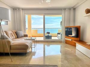 uma sala de estar com um sofá e uma televisão em Apartamento en Mascarat Beach, Urb Oasis Beach 1 em Altea