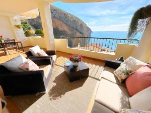uma sala de estar com sofás e vista para o oceano em Apartamento en Mascarat Beach, Urb Oasis Beach 1 em Altea