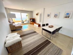 uma sala de estar com uma mesa e uma sala de jantar em Apartamento en Mascarat Beach, Urb Oasis Beach 1 em Altea