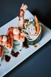 a white plate with sushi and vegetables on a table at Prinsotel La Dorada & Spa in Playa de Muro