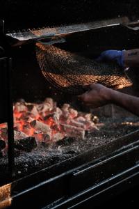 a person is cooking meat on a grill at Prinsotel La Dorada & Spa in Playa de Muro