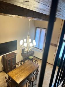 a dining room with a table and a chandelier at Agriturismo Pizzavacca in Villanova sullʼArda