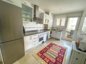 uma cozinha com armários brancos e um tapete no chão em Apartamento en Mascarat Beach, Urb Oasis Beach 1 em Altea