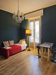 une chambre avec un lit, une table et un lustre dans l'établissement VM_LungoTicino Nassy, à Pavia 2 autres photos