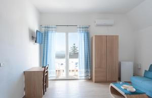 a living room with a blue couch and a sliding glass door at BeB con piscina Villa del Borgo in Badesi