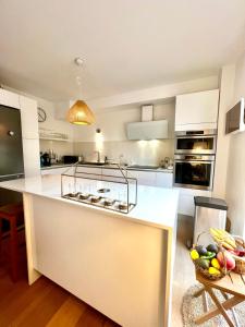 cocina con armarios blancos y encimera blanca en Sumptuous renovated apartment in Antibes en Antibes