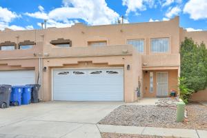 a house with two garage doors in front of it at Albuquerque Getaway Near Shopping and Fiesta Park! in Albuquerque