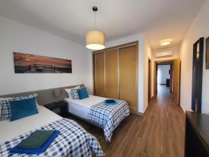 a hotel room with two beds and a hallway at " Villa Ocean View over the Sea " - A in Albufeira