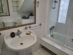 een witte badkamer met een wastafel en een bad bij Hotel O'Pazo in Vigo