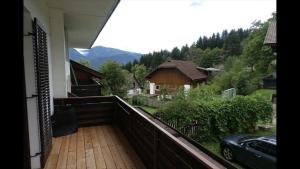 a balcony with a view of a house with a car at MARTUS APARTMAN in Matschiedl