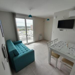 sala de estar con sofá azul y mesa en Apart Clematis, 1 dormitorio céntrico con balcón. en Río Cuarto
