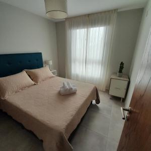 Un dormitorio con una cama con un par de toallas. en Apart Clematis, 1 dormitorio céntrico con balcón. en Río Cuarto