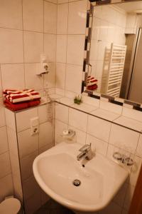 Hotel Kickert في Mettendorf: حمام أبيض مع حوض ومرآة