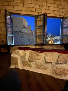 a room with two windows with a bed in front at mountain view house in Kerak