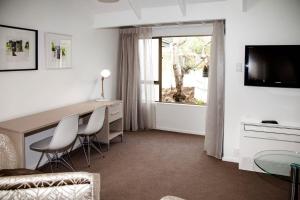 a room with a desk and chairs and a window at Aria on Bank in Dunedin