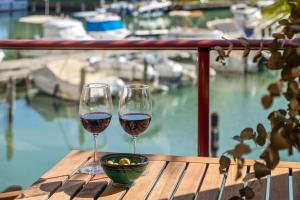 two glasses of wine on a table with a view of a marina at Palm Serenity - Sotogrande in Sotogrande