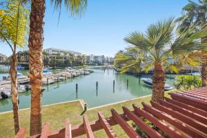 a view of a river with palm trees and a marina at Palm Serenity - Sotogrande in Sotogrande