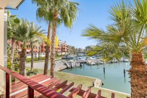a balcony with palm trees and a marina at Palm Serenity - Sotogrande in Sotogrande