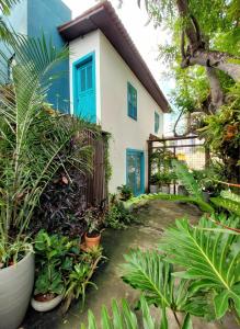 a house with a blue door and some plants at Residencial Casa Flor Atelier Botânico, Ponta Negra in Natal