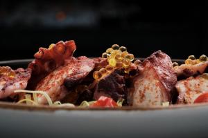 a plate of food with meat and other foods at Prinsotel La Dorada & Spa in Playa de Muro