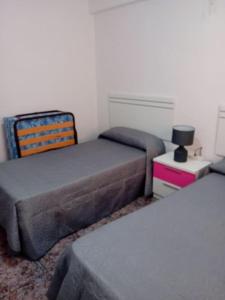 um quarto com 2 camas e um candeeiro numa mesa de cabeceira em Alojamiento Auri em Almuñécar