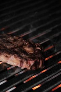 a piece of meat cooking on a grill at Prinsotel La Dorada & Spa in Playa de Muro