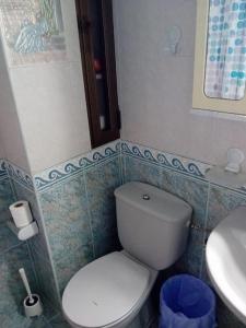 uma casa de banho com um WC branco e um lavatório. em Alojamiento Auri em Almuñécar