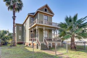 a house with palm trees in front of a fence at Coastal Galveston Studio about 1 Mi to Beach! in Galveston