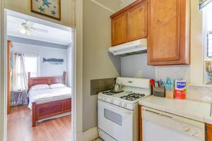 a small kitchen with a stove and a bedroom at Coastal Galveston Studio about 1 Mi to Beach! in Galveston