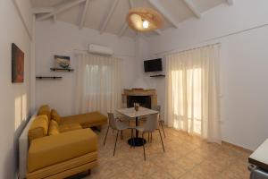 Lagouvardos Apartments في ماراثوبوليس: غرفة معيشة مع أريكة وطاولة