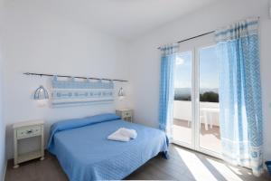 a blue bedroom with a bed and a balcony at BeB con piscina Villa del Borgo in Badesi +40 photos