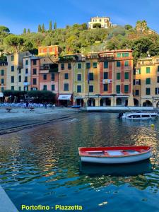 una barca rossa in acqua di fronte agli edifici di Portofino's Flavour a Portofino