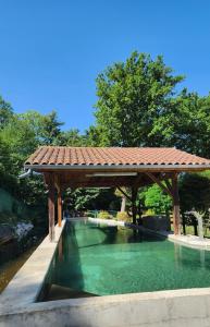 - une piscine avec un kiosque en bois dans l'établissement Détendez-vous à Montverdun, à Montverdun