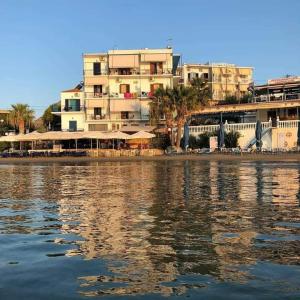 a large building on the shore of a body of water at Svetlana & Michalis Oasis Hotel in Agia Marina Aegina