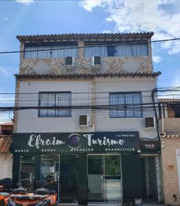 a building with a sign in front of it at Suítes Viver Arraial do Cabo in Arraial do Cabo