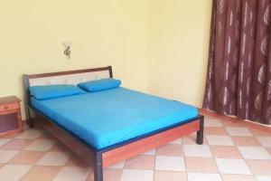 a bed with blue sheets in a room with a window at Adorable 2bedroom homestay in Beau Bassin
