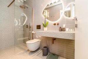 a bathroom with a toilet and a sink and a mirror at Villa Ghisi Apartments in Zadar