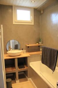 La salle de bains est pourvue d'un lavabo, d'un miroir et d'une baignoire. dans l'établissement Le Cœur du Bien-être - Gîte grande capacité - Superbe emplacement - Vue Seine - Décoration soignée - Coin touristique, aux Andelys