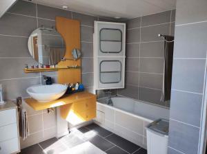 La salle de bains est pourvue d'un lavabo et d'une baignoire. dans l'établissement Chambre proche paris JO 2024, à Chaumontel